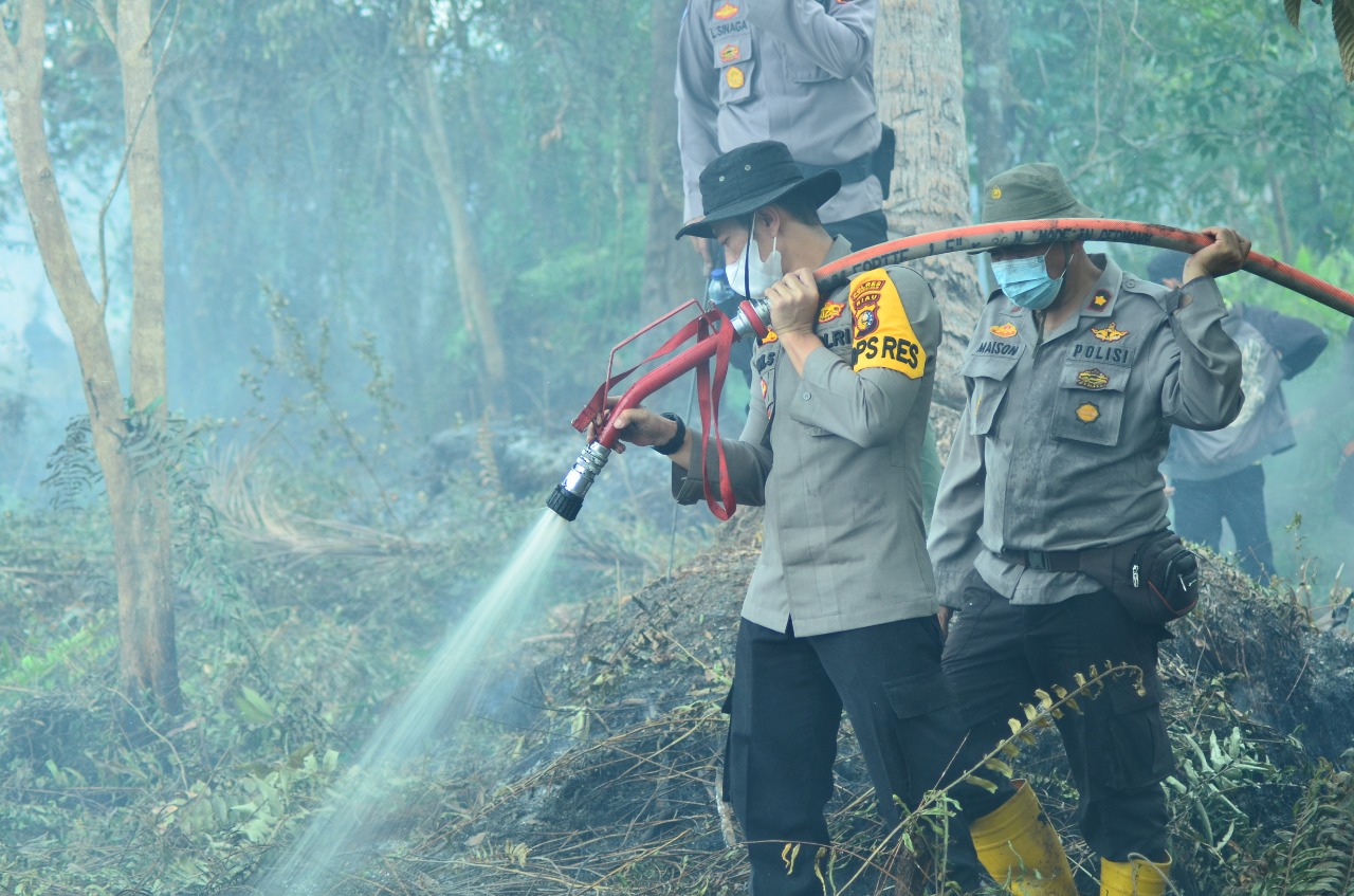 Polres Inhil Lakukan Pendinginan Terhadap Lahan Yang Terbakar di Kecamatan Tempuling